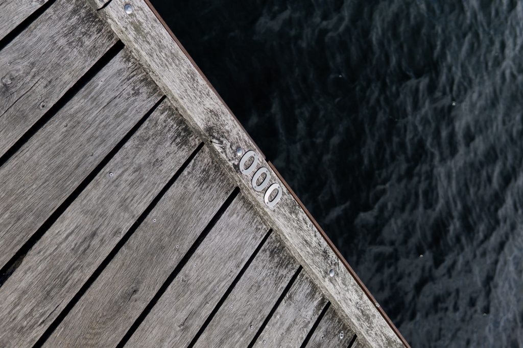 Metal numerals 000 nailed to a wooden dock. t