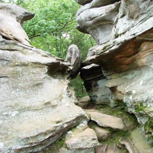 A boulder wedged between two cliffs.